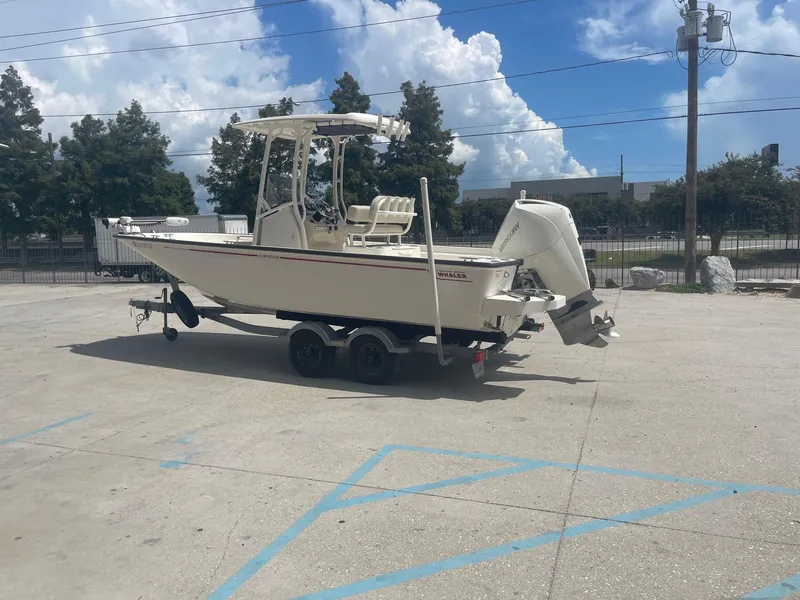 Slide: The Image of 2019 Boston Whaler 210 Montauk boat on a trailer in a parking lot. - 5