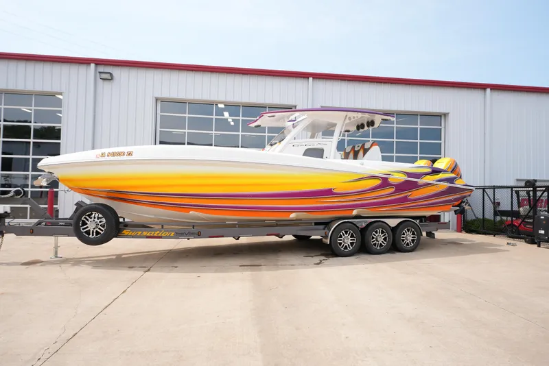 The Image of 2014 Sunsation 34 CCX boat with vibrant yellow and purple design on a trailer. - 0