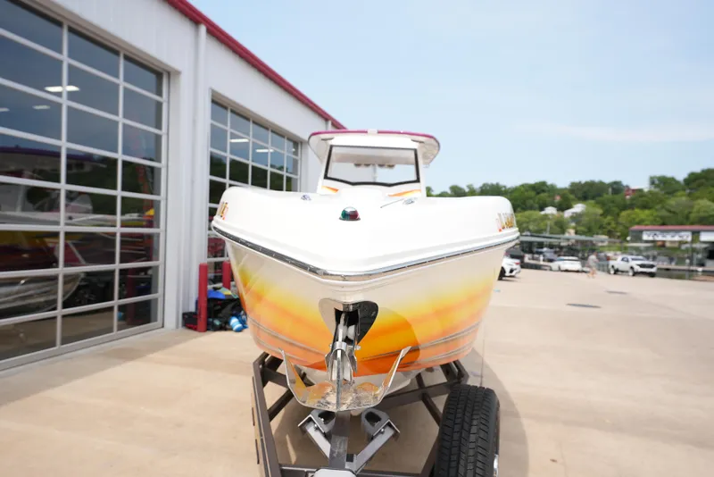 Slide: The Image of 2014 Sunsation 34 CCX boat on a trailer outside a garage. - 2