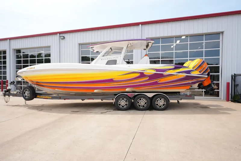 Slide: The Image of 2014 Sunsation 34 CCX boat with vibrant yellow and purple graphics on a trailer. - 3