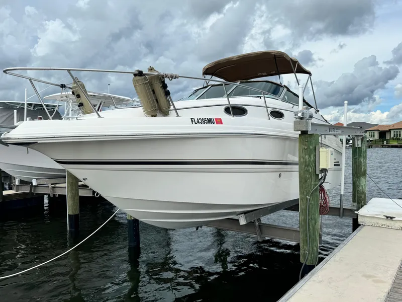 Slide: The Image of 2004 Chaparral Signature 260 boat docked on a lift under cloudy skies. - 1