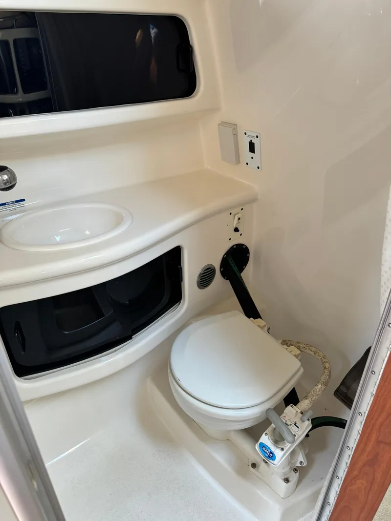 Slide: The Image of 2004 Chaparral Signature 260 boat bathroom with sink and toilet. - 14