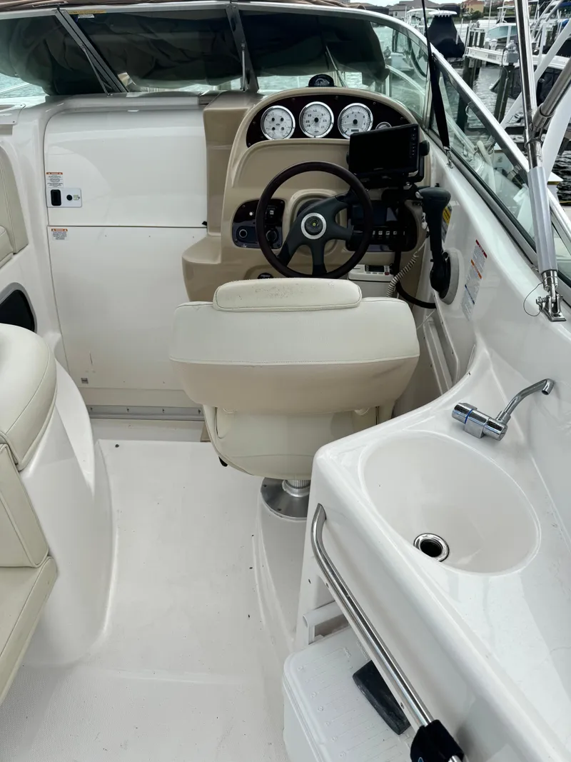 Slide: The Image of 2004 Chaparral Signature 260 boat cockpit with steering wheel, gauges, and sink. - 3