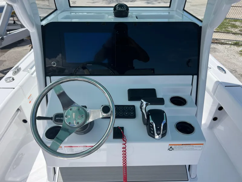 Slide: The Image of 2024 Sportsman Masters 247OE Bay Boat helm with steering wheel and control panel. - 7