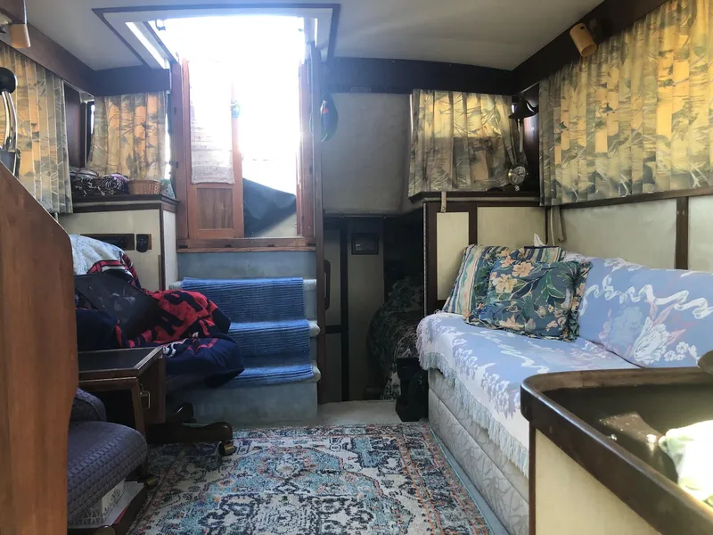 Slide: The Image of Interior of 1983 Carver 32 Aft Cabin with cozy seating and vintage decor. - 10