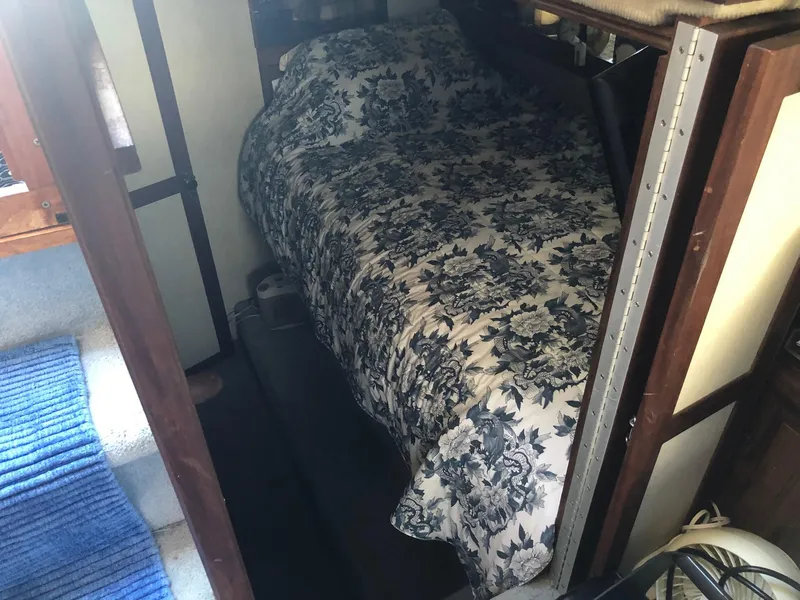 Slide: The Image of 1983 Carver 32 Aft Cabin interior with a cozy bed and floral bedspread. - 11