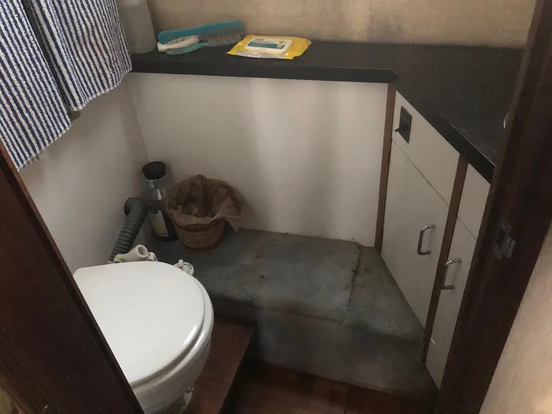 Slide: The Image of 1983 Carver 32 Aft Cabin bathroom with toilet, sink, and storage cabinets. - 13