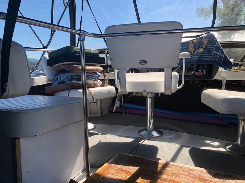 Slide: The Image of Interior of 1983 Carver 32 Aft Cabin boat with white seating and helm station. - 2