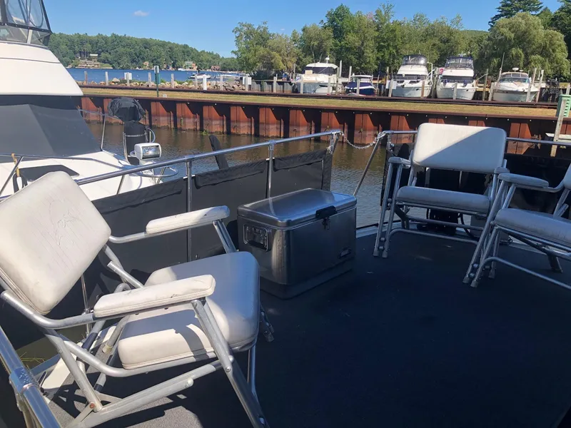Slide: The Image of 1983 Carver 32 Aft Cabin boat deck with chairs and cooler at marina. - 3