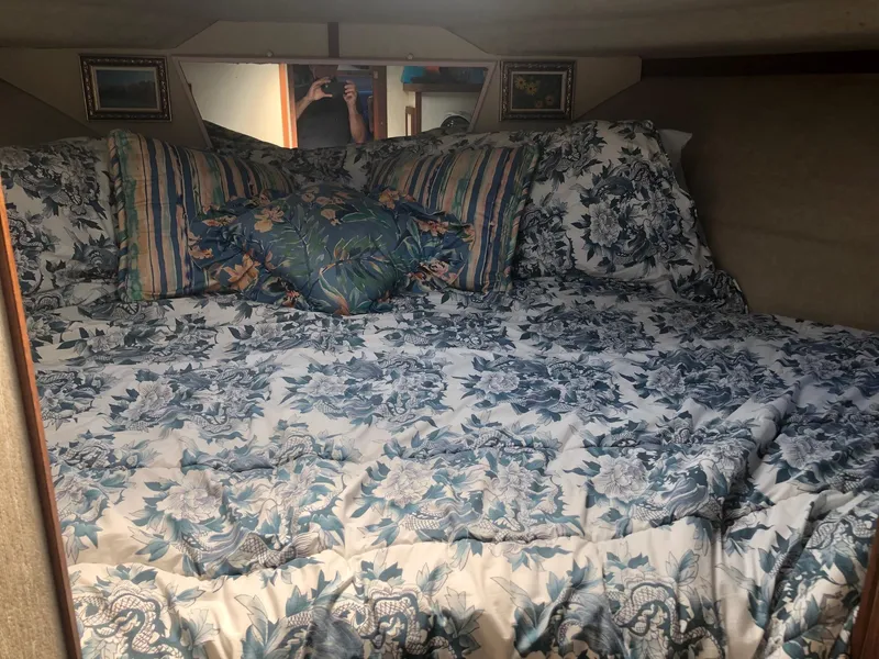 Slide: The Image of 1983 Carver 32 Aft Cabin bedroom with floral bedding and decorative pillows. - 7