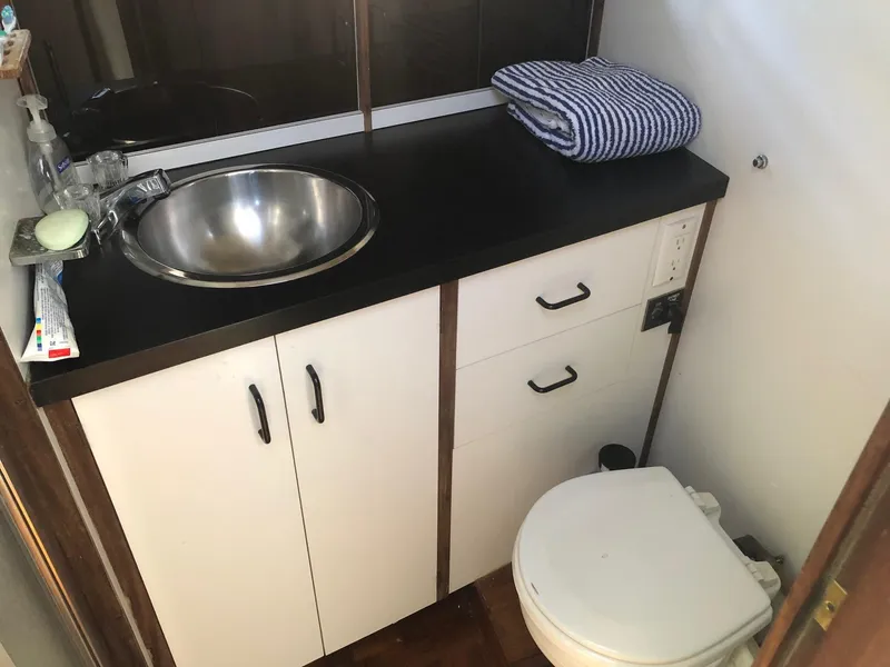 Slide: The Image of 1983 Carver 32 Aft Cabin bathroom with sink, storage cabinets, and toilet. - 8