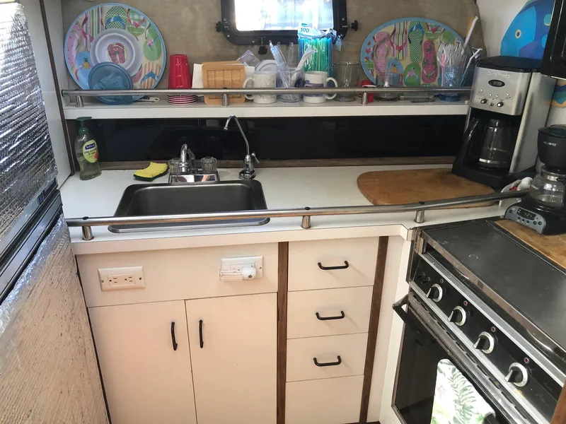 Slide: The Image of 1983 Carver 32 Aft Cabin kitchen with sink, stove, and countertop appliances. - 9
