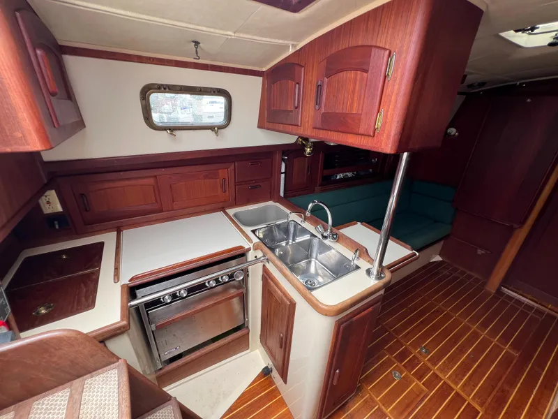 Slide: The Image of 1994 Pacific Seacraft 34 yacht interior with wooden cabinetry and dual sink. - 34