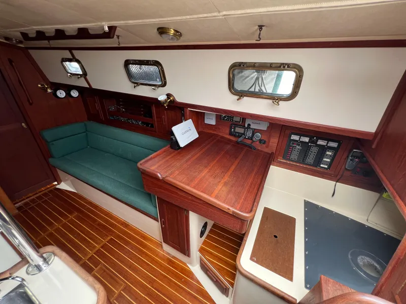 Slide: The Image of Interior of a 1994 Pacific Seacraft 34 sailboat with wooden finishes and green seating. - 39