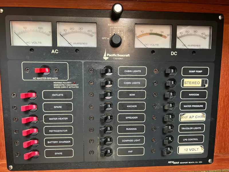 Slide: The Image of 1994 Pacific Seacraft 34 electrical control panel with AC and DC switches and meters. - 46