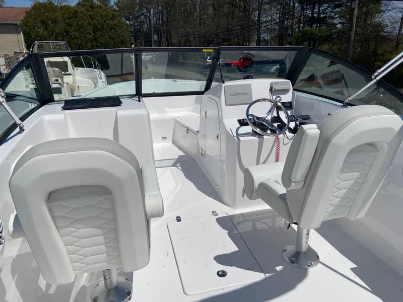 Slide: The Image of 2024 Aquasport 2200 Dual Console boat interior with white seating and steering console. - 5