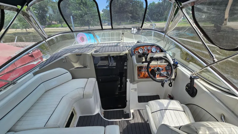 Slide: The Image of Interior of 1998 Bayliner 2855 Ciera boat with white seating and wooden dashboard. - 11