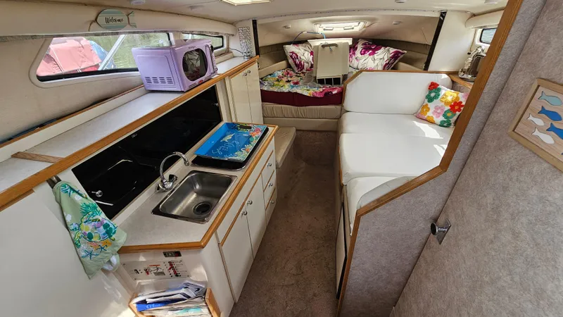 Slide: The Image of 1998 Bayliner 2855 Ciera interior with kitchen, seating, and sleeping area. - 13