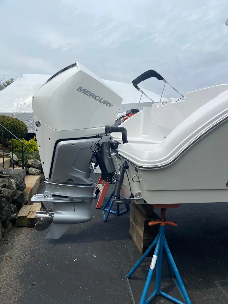 Slide: The Image of 2024 Aquasport 2400CS boat with Mercury outboard motor on stands. - 2