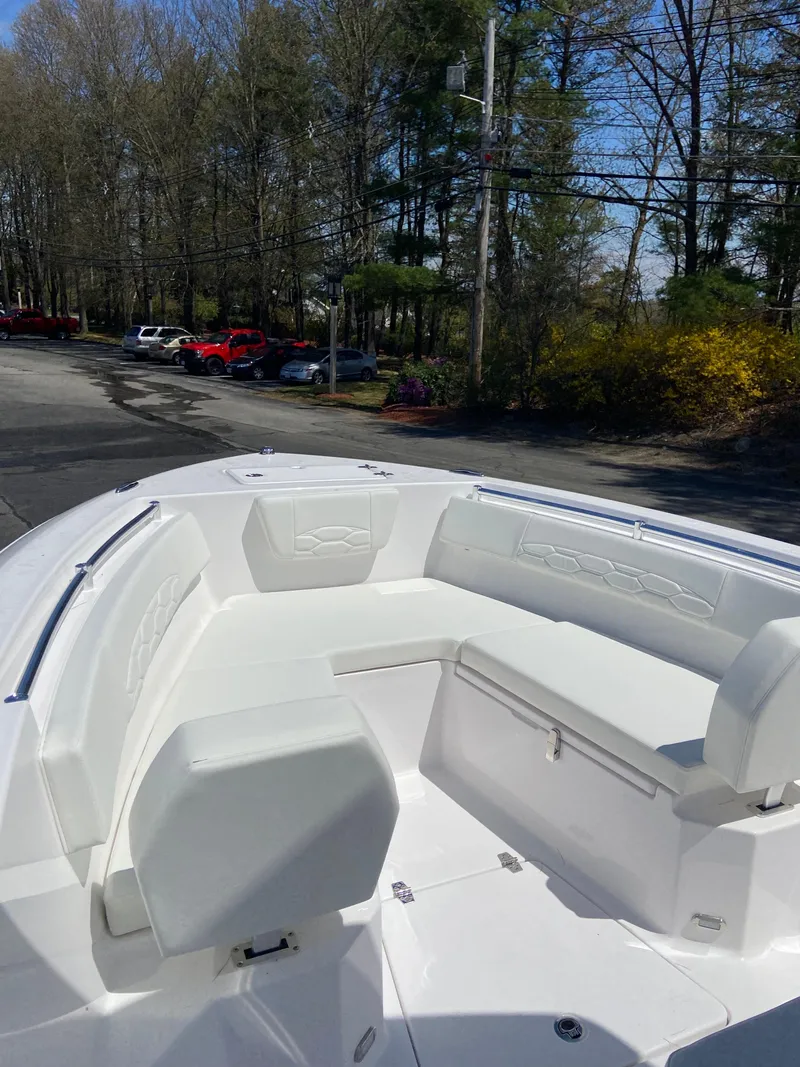 Slide: The Image of 2024 Aquasport 2400CS boat with white seating and spacious deck. - 4