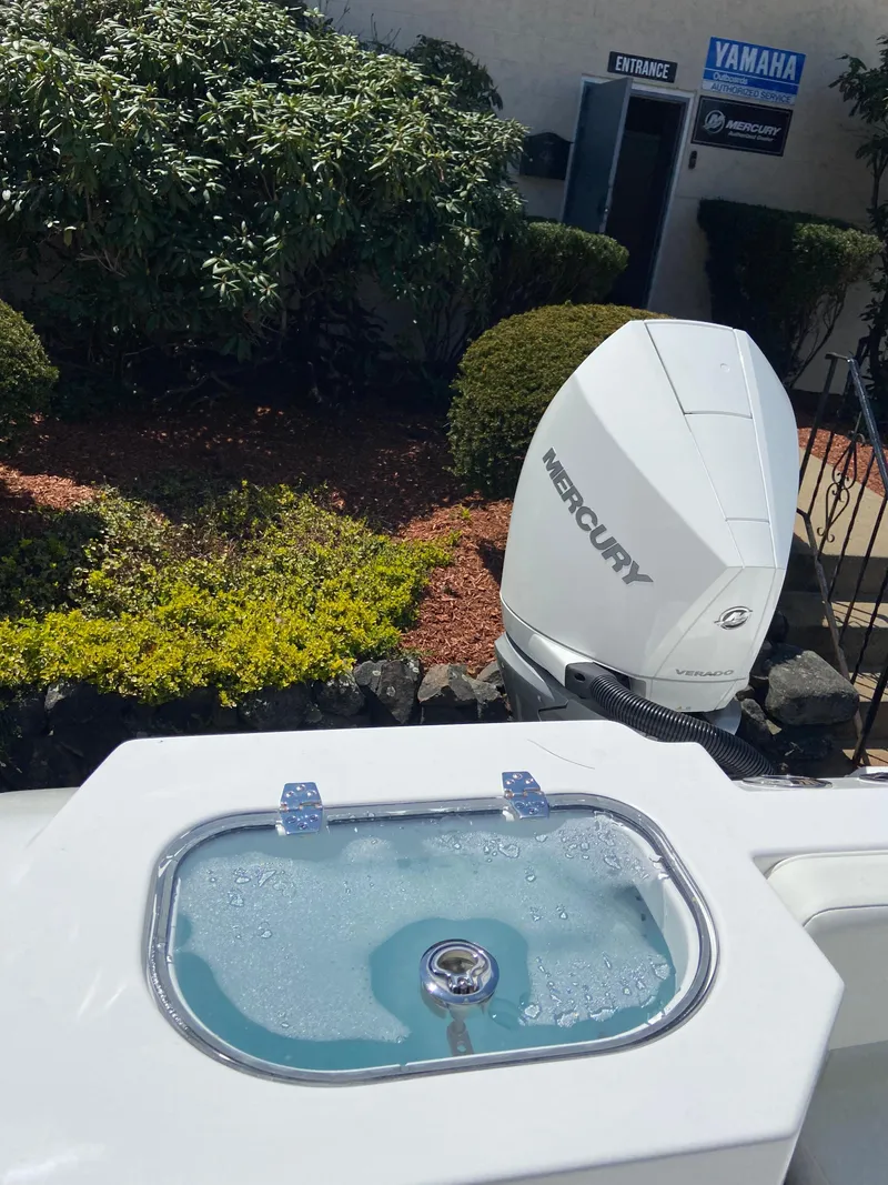 Slide: The Image of 2024 Aquasport 2400CS boat with Mercury outboard motor and livewell. - 6
