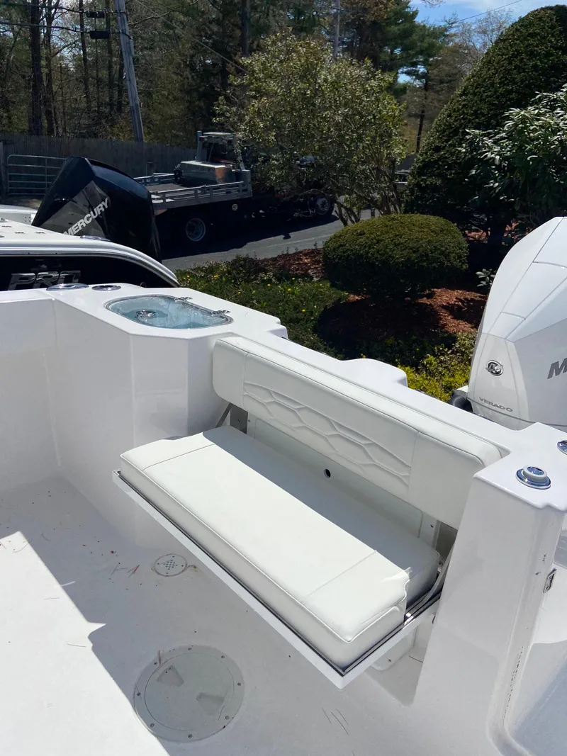 Slide: The Image of 2024 Aquasport 2400CS boat with white seating and outboard motor. - 7