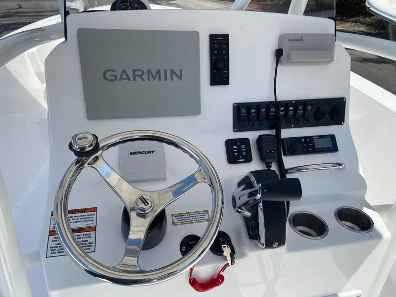 Slide: The Image of 2024 Aquasport 2400CS boat dashboard with Garmin navigation system and Mercury steering wheel. - 9