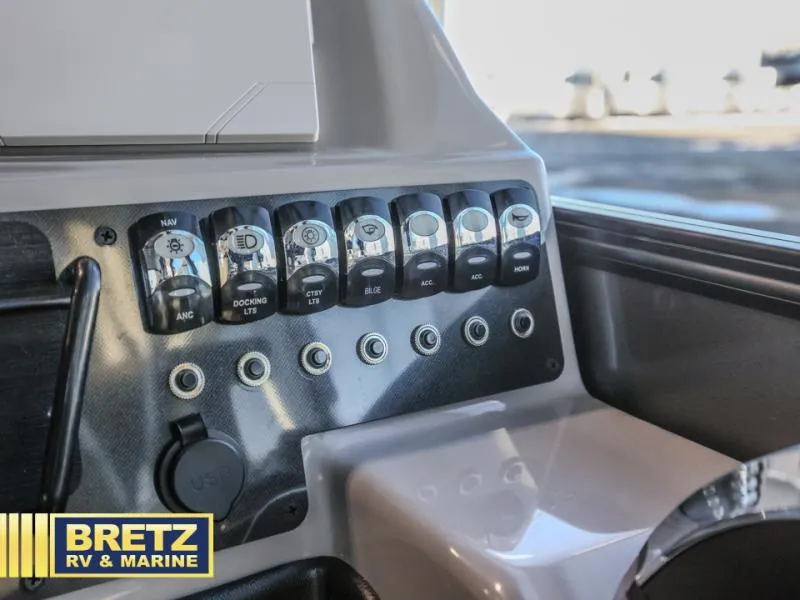 Slide: The Image of Control panel of 2025 Aria A22CC boat with labeled switches and USB port. - 12