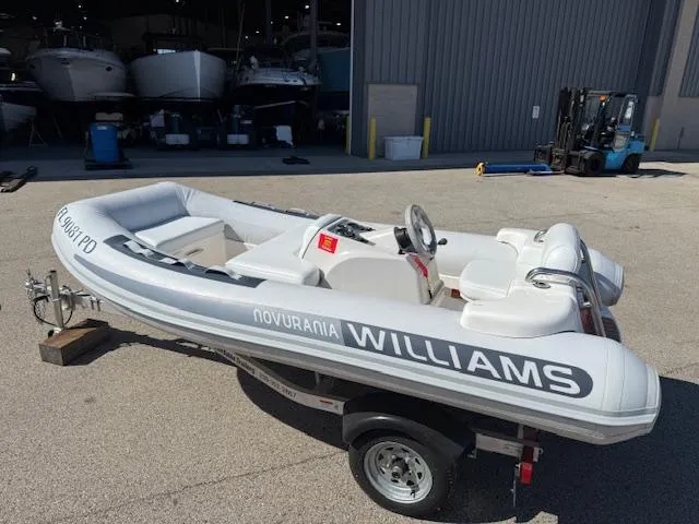 Slide: The Image of 2011 Williams Jet Tenders Turbojet 325 on trailer, parked outside a warehouse. - 8