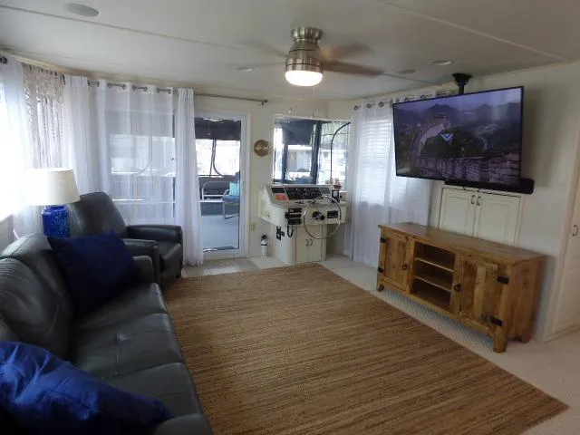 Slide: The Image of Spacious living area in a 2003 Sunstar 16x65 houseboat with modern amenities. - 3