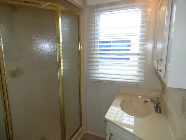 Slide: The Image of Compact bathroom in a 2003 Sunstar 16x65 houseboat with shower and sink. - 9