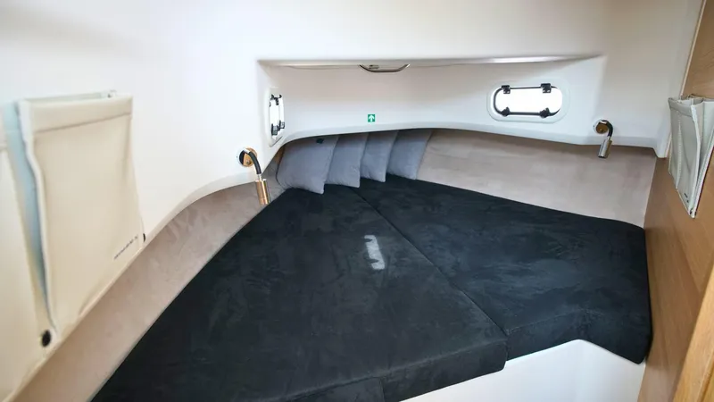 Slide: The Image of 2024 Nimbus Tender 9 #143 cabin interior with black bedding and porthole windows. - 11