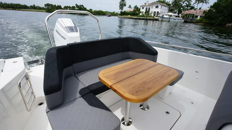 Slide: The Image of Luxurious seating area on the 2024 Nimbus Tender 9 #143 boat with a wooden table. - 14