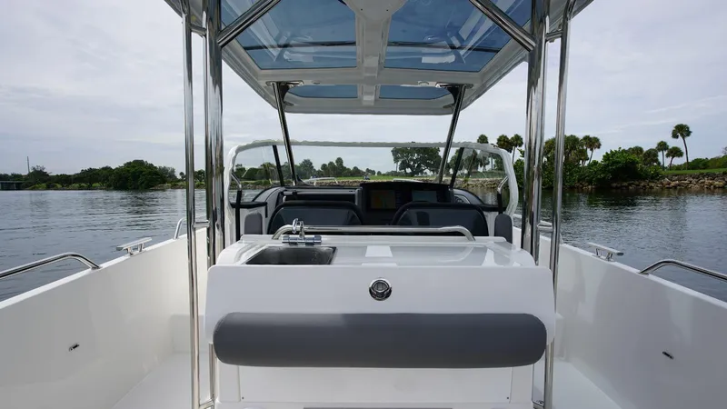 Slide: The Image of 2024 Nimbus Tender 9 #143 boat interior with sink and seating, on calm water. - 6
