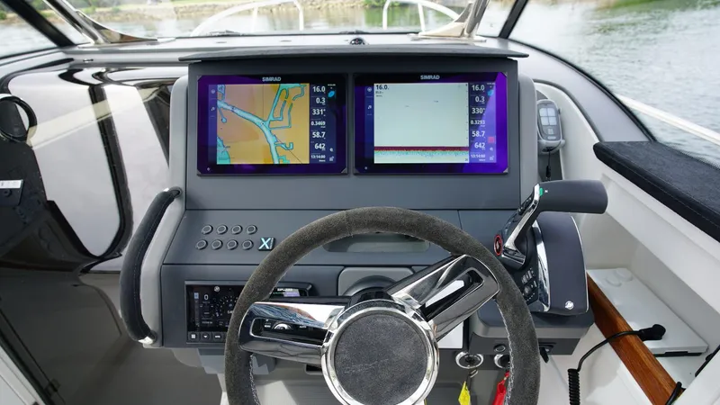 Slide: The Image of Nimbus Tender 9 #143 2024 boat dashboard with dual navigation screens and steering wheel. - 9