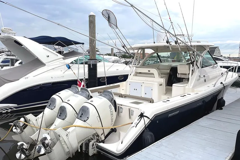 Slide: The Image of 2009 Pursuit OS 375 Offshore boat docked with triple outboard engines. - 0