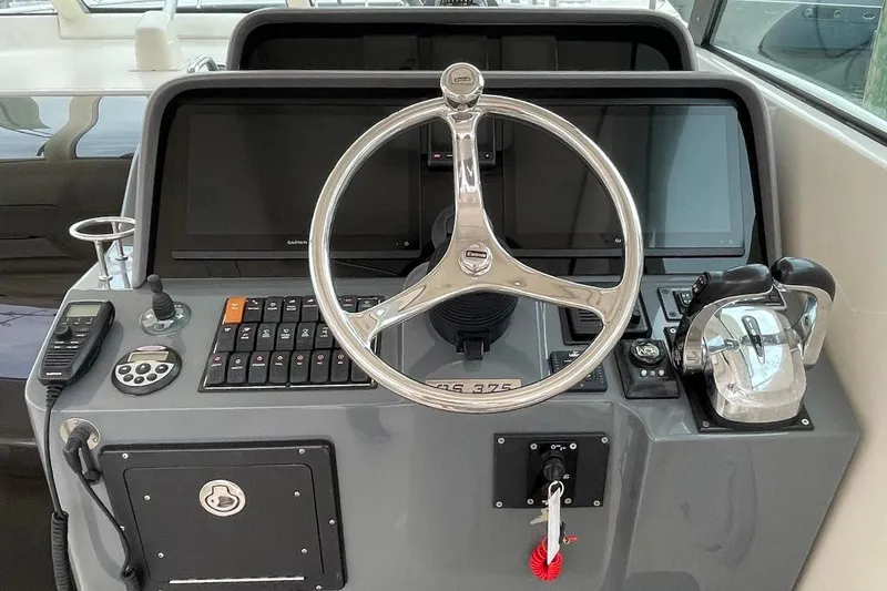 Slide: The Image of 2009 Pursuit OS 375 Offshore helm with steering wheel and control panel. - 1