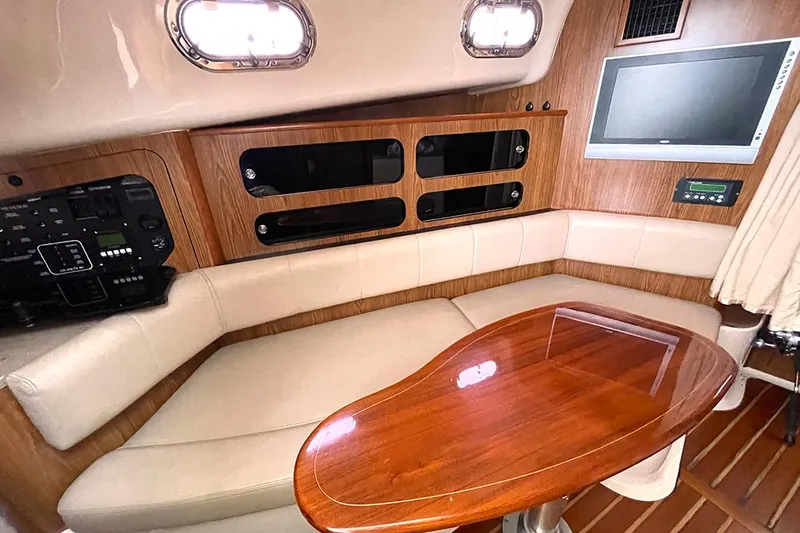 Slide: The Image of 2009 Pursuit OS 375 Offshore cabin interior with seating, table, and TV. - 17