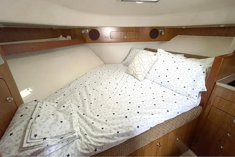 Slide: The Image of Cozy cabin bed in 2009 Pursuit OS 375 Offshore boat with star-patterned bedding. - 18