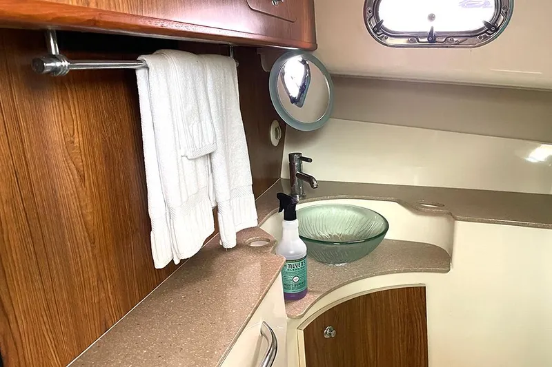 Slide: The Image of 2009 Pursuit OS 375 Offshore bathroom with glass sink and wooden cabinetry. - 19