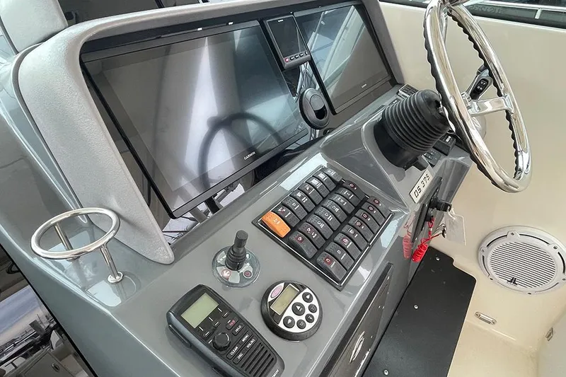 Slide: The Image of 2009 Pursuit OS 375 Offshore boat helm with modern navigation and communication equipment. - 2