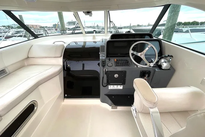Slide: The Image of 2009 Pursuit OS 375 Offshore boat helm with steering wheel and seating. - 7
