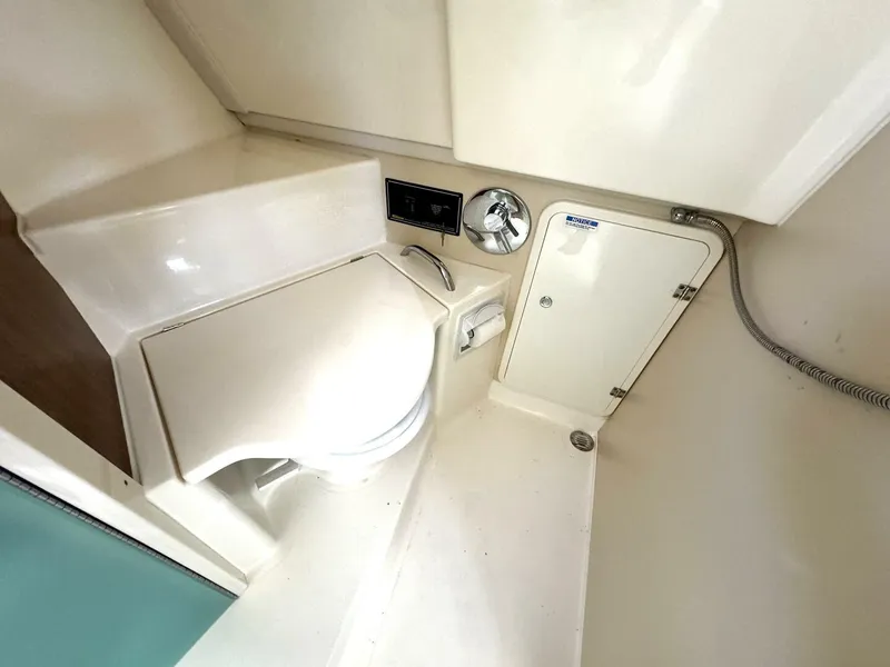Slide: The Image of 2010 Pursuit OS 345 Offshore boat bathroom with toilet and storage. - 14