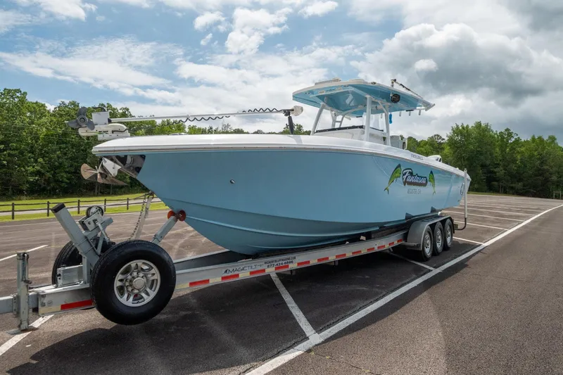 Slide: The Image of 2019 Fountain 34CC boat on a trailer in a parking lot. - 16