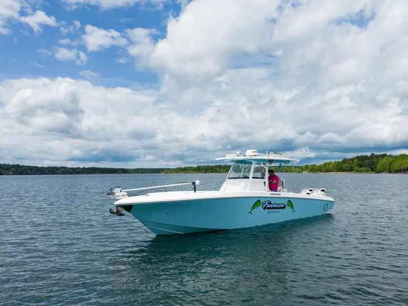 Slide: The Image of 2019 Fountain 34CC boat on a lake under a partly cloudy sky. - 4