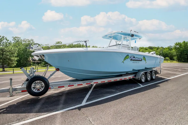 Slide: The Image of 2019 Fountain 34CC boat on a trailer in a parking lot. - 5