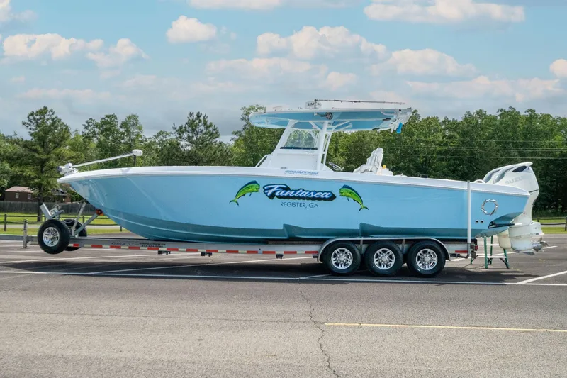 Slide: The Image of 2019 Fountain 34CC boat on a trailer in a parking lot. - 6