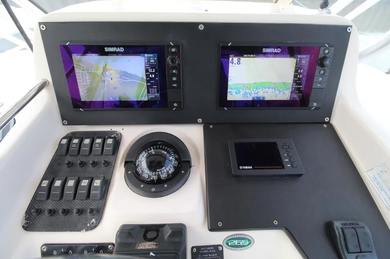 Slide: The Image of Grady-White Express 265 2002 boat dashboard with Simrad displays and Yamaha controls. - 11