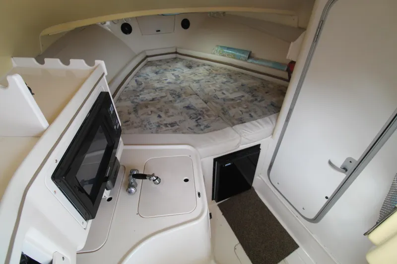 Slide: The Image of 2002 Grady-White Express 265 cabin interior with bed, sink, and microwave. - 15