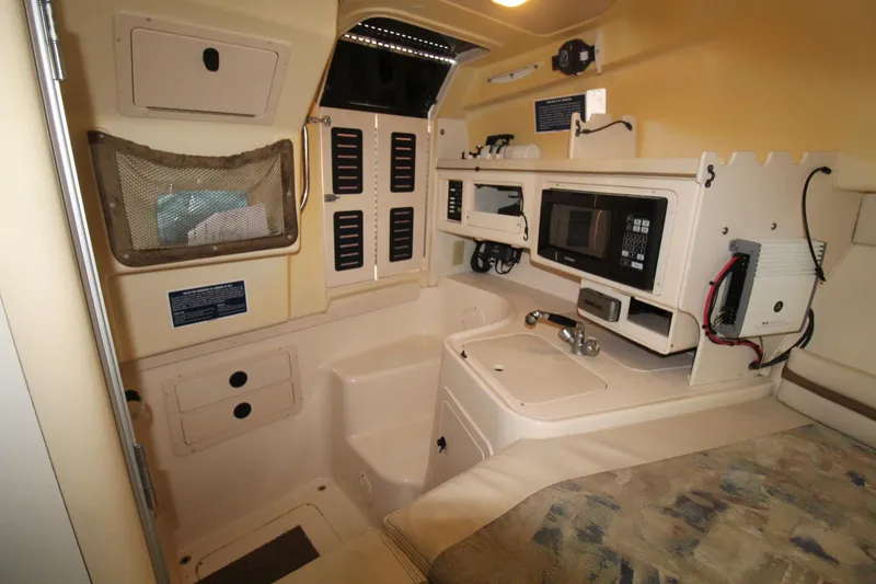 Slide: The Image of 2002 Grady-White Express 265 cabin interior with kitchenette and storage compartments. - 18